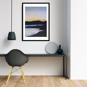 An ethereal art print showcasing a colorful sunset reflected on a still lake, with vibrant oranges and blues illuminating the sky.
