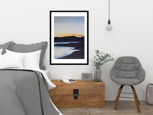 A stunning portrayal of a sunset transitioning into twilight, with gentle waves shimmering in the fading light of the lake.